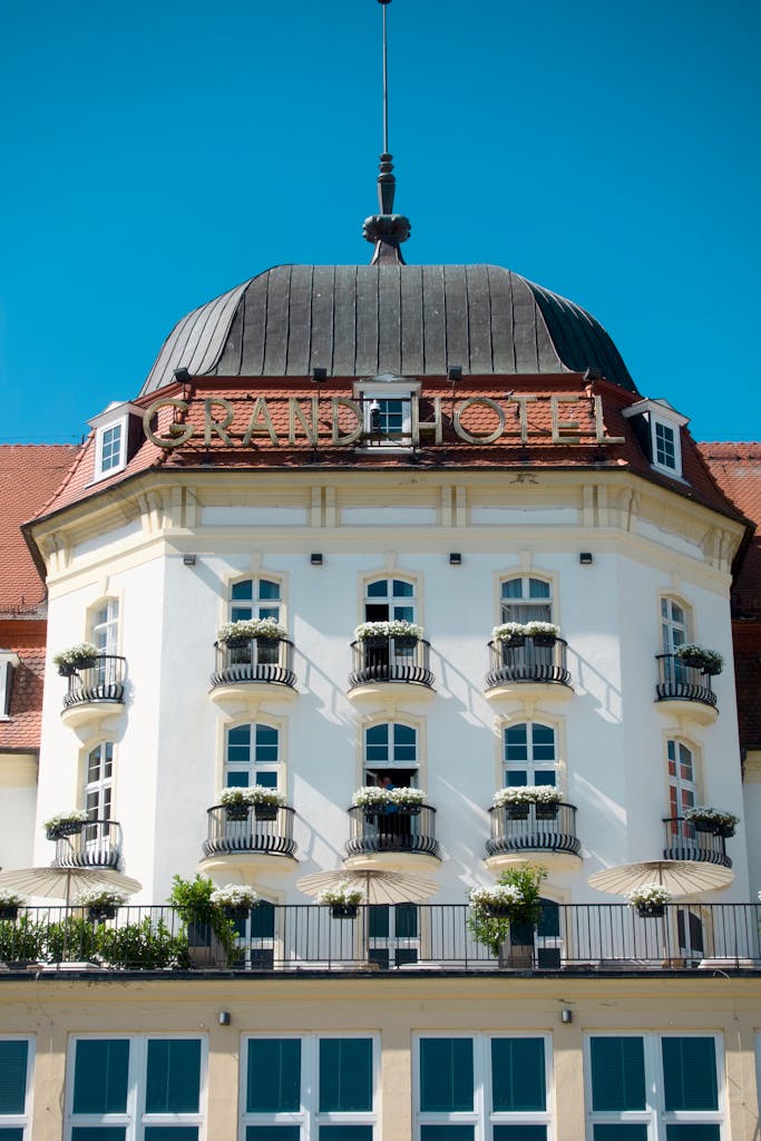 Front view of a historic grand hotel with classic architecture and blue sky backdrop.